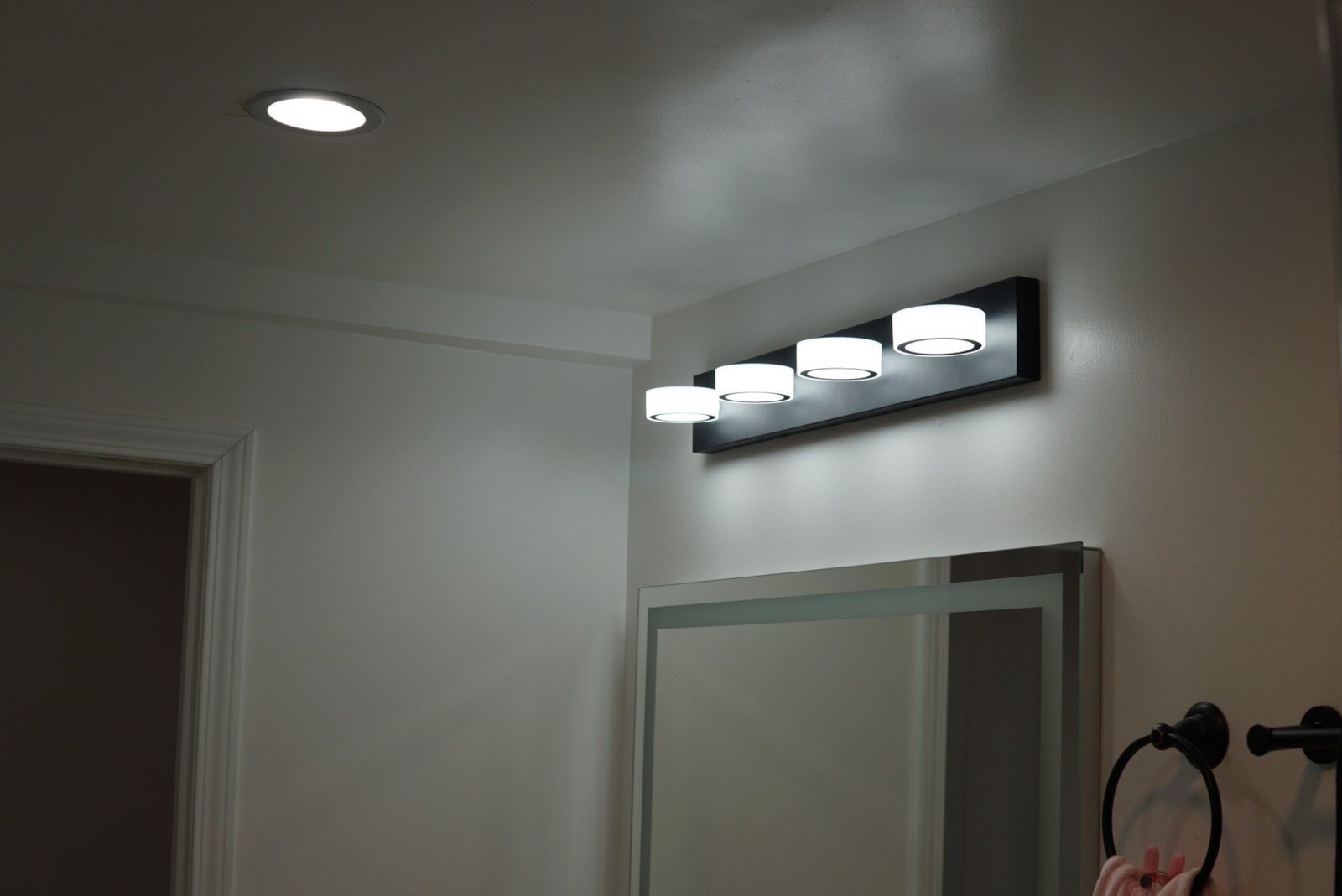 Bathroom vanity with recessed lighting and integrated mirror lighting for a seamless modern look.