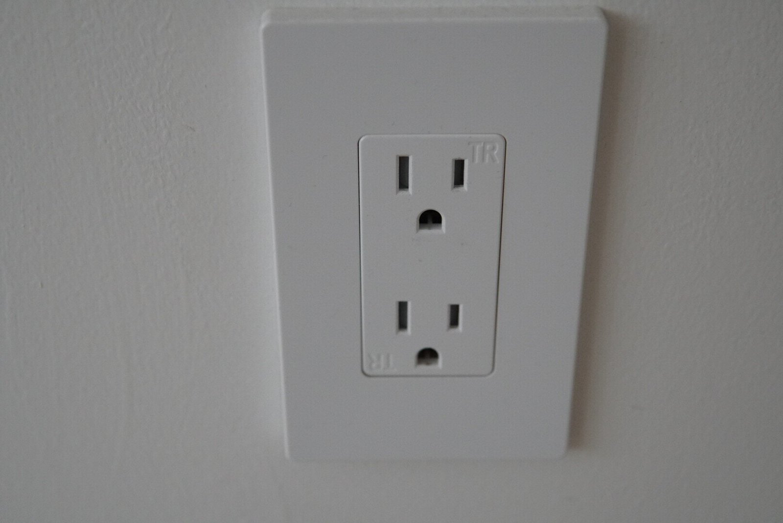 Close-up of a GFCI electrical outlet installed in a hallway, designed for enhanced safety and compliance with modern electrical standards.