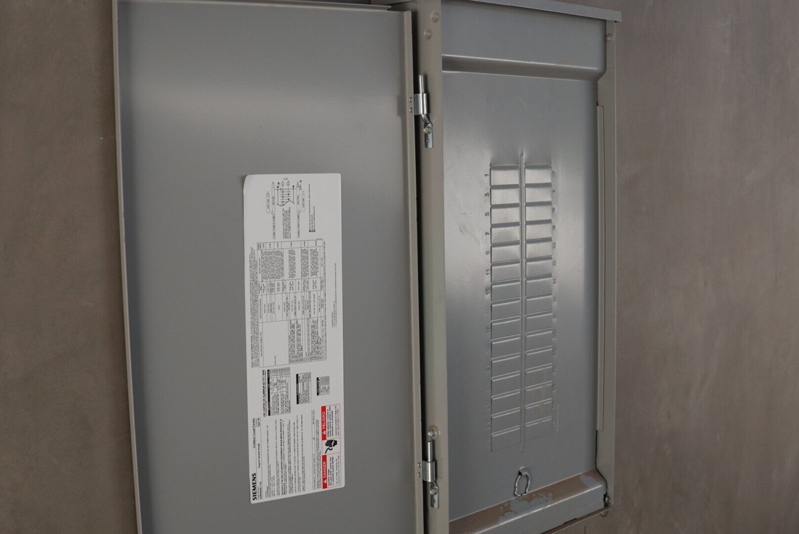 An open electrical circuit breaker panel showing multiple breaker slots ready for installation.