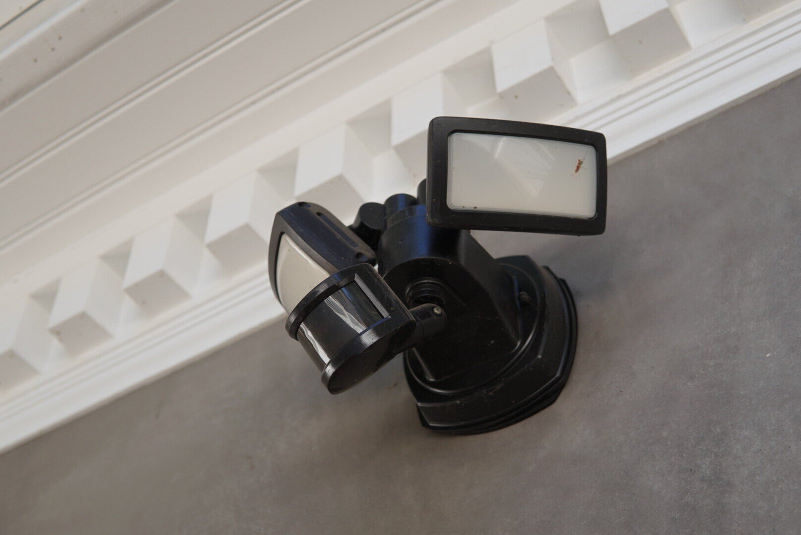 Motion-activated security light with dual floodlight design installed on an outdoor wall.