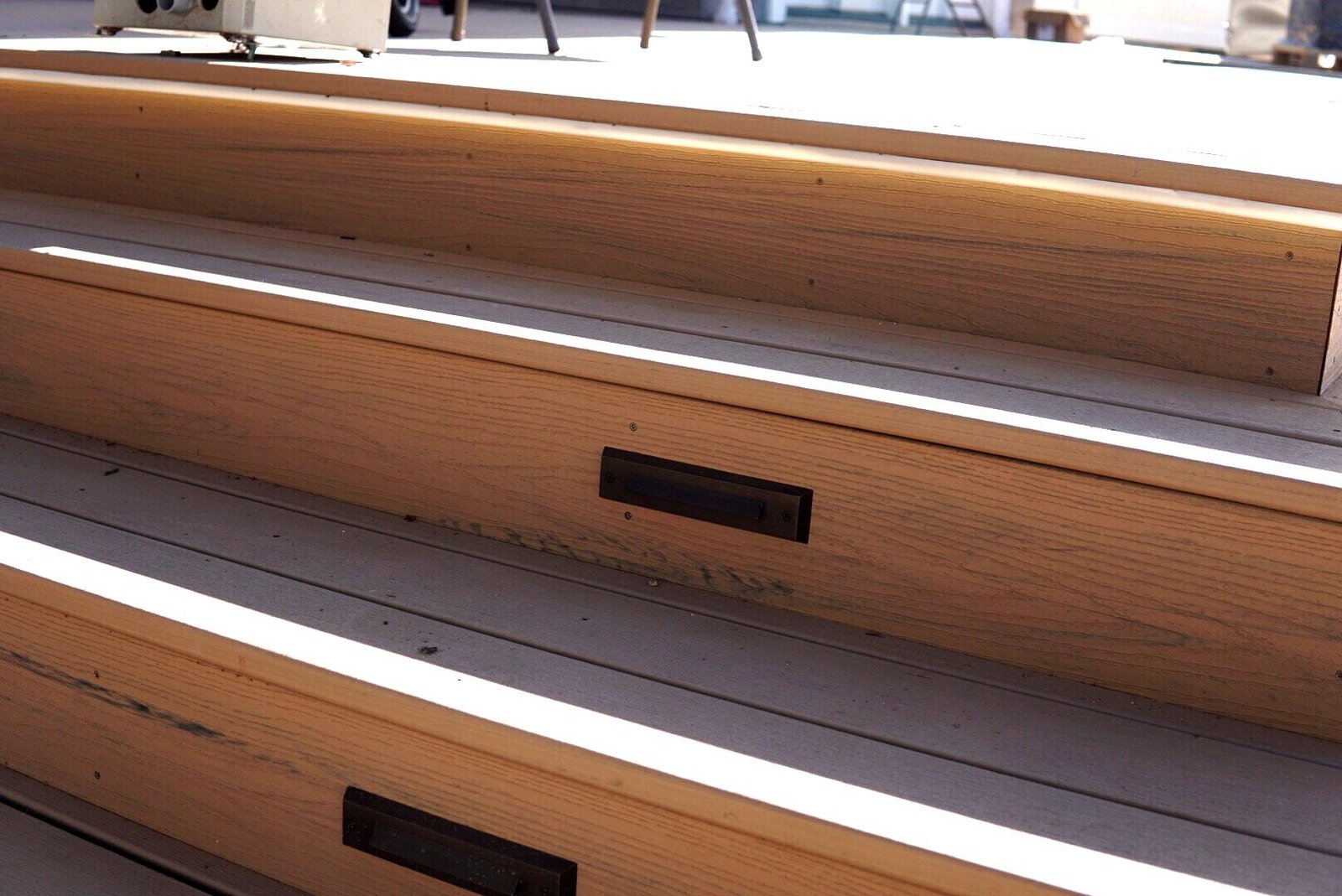 Wooden outdoor steps with built-in LED lighting, enhanced to showcase clean lines and modern design under natural daylight.