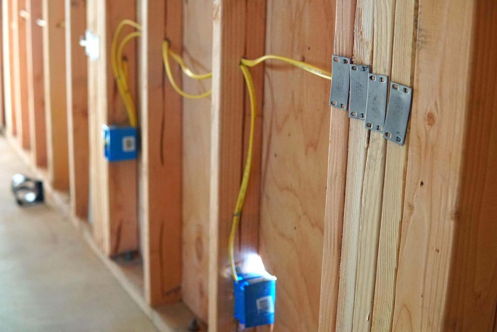 New construction wiring featuring GFCI wires, a GFCI electrical box, and visible framing, showcasing the progress of a residential electrical installation.